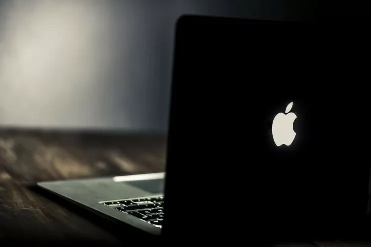 Open laptop on a wooden desk in a dark room