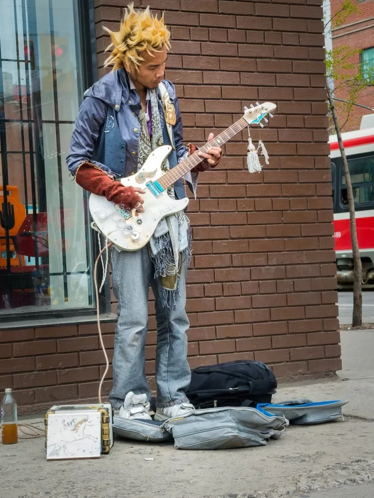 musician busking in formal attire on a busy street