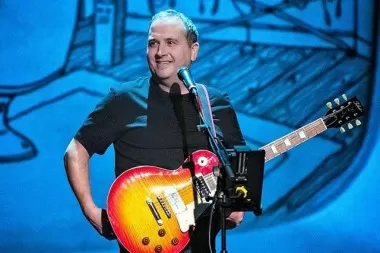 Musician performing live on stage with an electric guitar