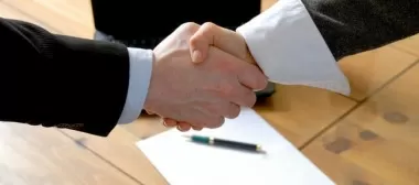 Band and promoter shaking hands after agreeing a gig contract