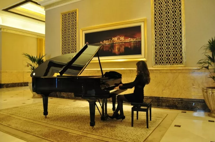 Cocktail pianist playing grand piano in a hotel lobby