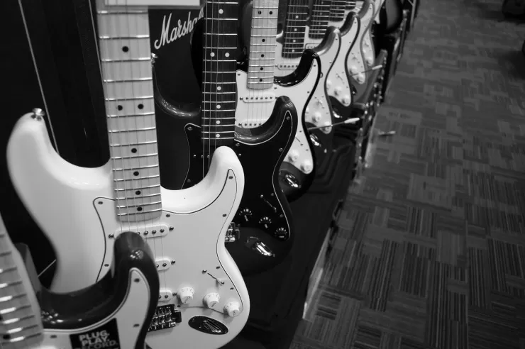 Row of electric guitars in black and white with Marshall amplifier